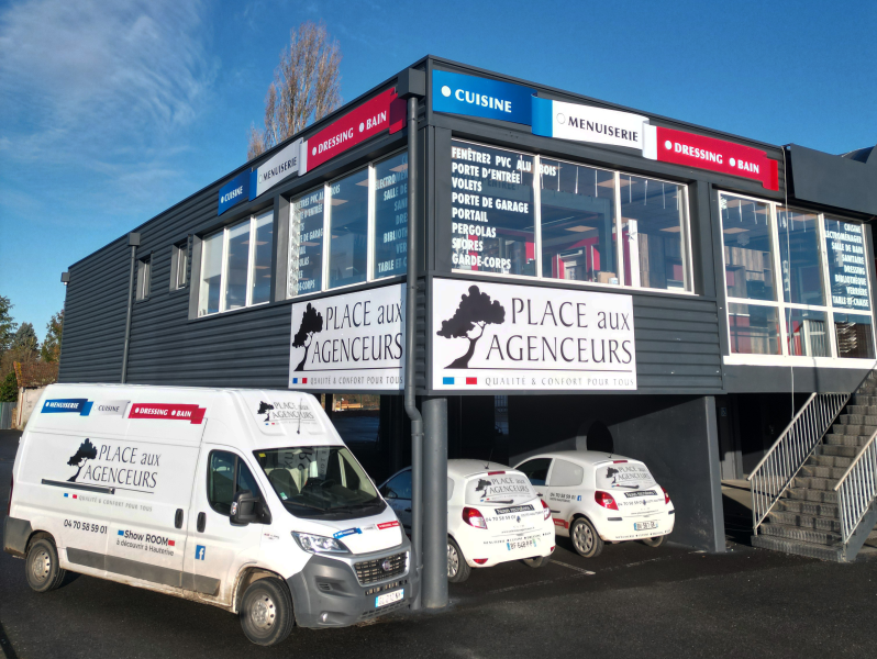 Façade du showroom Place aux Agenceurs avec véhicules de l'entreprise – Spécialiste en menuiserie, cuisine, dressing et salle de bain.